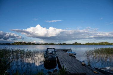 Bulutların ve mavi gökyüzünün ardında büyük, güzel bir göl manzarası.