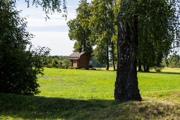 Kırsal alanlar yeşil tarlalar, ağaçlar ve açık alanlar bulutlu bir gökyüzüne karşı.