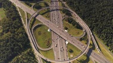 Hareket halindeki arabalarla, insansız hava aracının arka planından çekilen karmaşık bir kavşak sistemine sahip bir yolun panoramik görüntüsü.