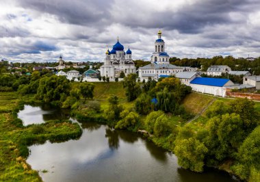 panoramic view of the old white stone monastery with blue domes filmed from a drone clipart