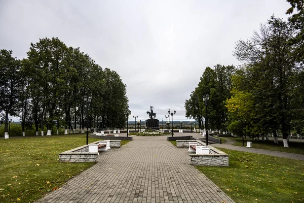 Tepedeki bir parkta gri gökyüzüne karşı bronz binici