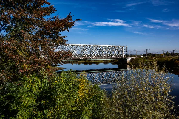 bridge over the river and the reflection of the metal railway bridge in the river