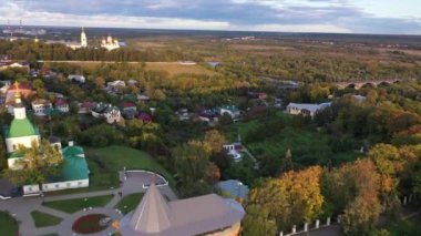 Şehrin panoramik manzarası. Eski kiliseler ve binalar. İnsansız hava aracından çekilen yeşil ağaçların arka planına karşı.