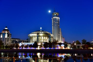 Şafak vakti büyük bir metropolün nehir kenarına parlayan fenerlerin yansımasıyla.
