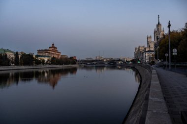 Şafak vakti büyük bir metropolün nehir kıyısında yansımaları var.