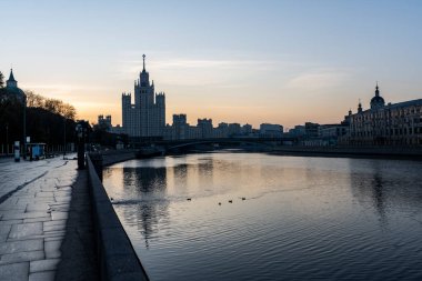 Şafak vakti büyük bir metropolün nehir kıyısında yansımaları var.