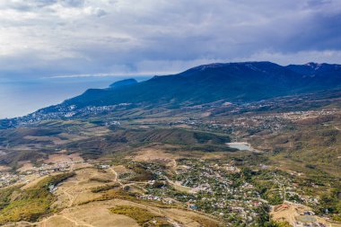 Gökyüzünün arka planında sıradışı çıkıntıları ve hikayeleri olan güzel dağlar ve bir drondan çekilen vadi.