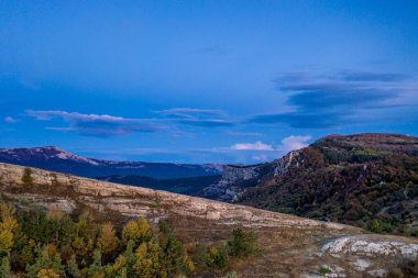 Güneşin doğuşundaki güzel dağlar beyaz bulutların arka planında