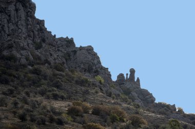 Dağların ve vadinin panoramik manzarasına karşı yeşil çam ağaçları ve sonbahar gökyüzü