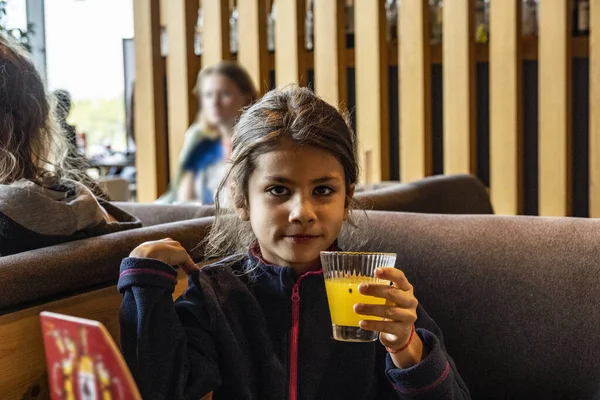 Girl Blue Sweater Drinks Orange Juice Table — Stock Photo, Image