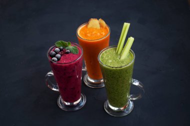 Taze pembe, yeşil ve turuncu meyve püresi. Parlak ve renkli bir resim. Sağlıklı vejetaryen içeceği.