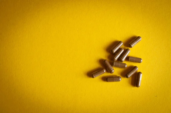 Isolated medicine pills on yellow background.
