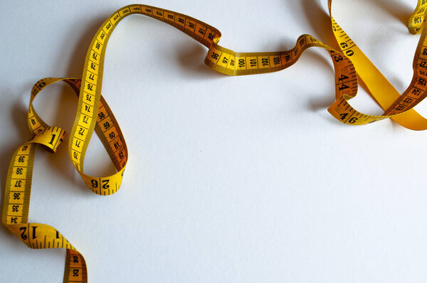 Yellow measuring tape isolated on white background. The concept of diet.