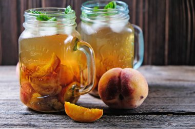 ahşap masa üzerinde seçici odak ile şeftali çay kavanozu vurdu