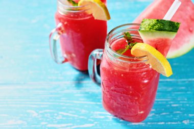 Karpuz yaz buz ve nane yaprakları ile kokteyl. Soğuk içecek organik sigara-alkol içki pastel mavi ahşap arka plan kopya alanı ile.