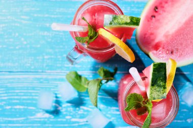 Karpuz yaz buz ve nane yaprakları ile kokteyl. Soğuk içecek pastel mavi ahşap arka plan kopya alanı ile organik sigara-alkol içki. Üstten görünüm.