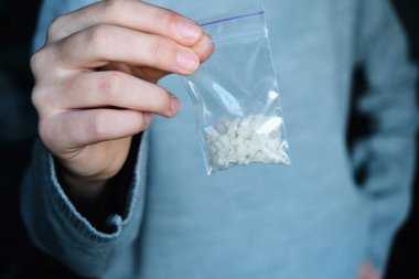 paket beyaz narkotik - kokain, meth veya başka bir ilaç closeup ile el tutar