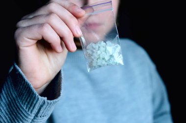 paket beyaz narkotik - kokain, meth veya başka bir ilaç closeup ile el tutar