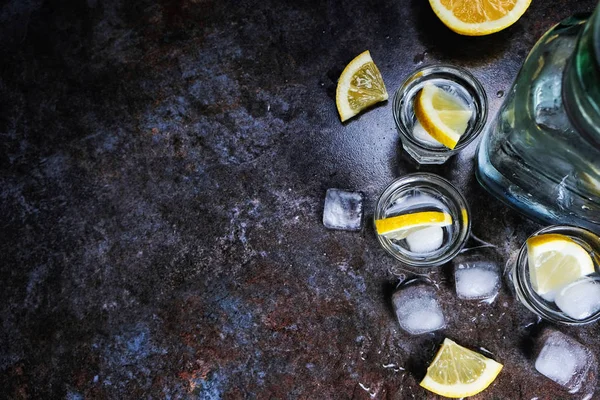 Tequila vodka coups et bouteille avec des tranches de citron, vue sur le dessus — Photo