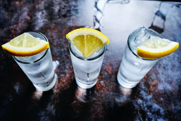 Vodka ou gim ou tequila em copos de tiro na mesa de pedra Fotografia De Stock