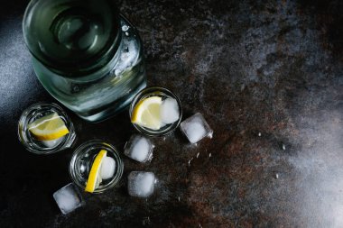 Votka limon ve buz bardaklarda. Siyah taş masanın üstünde. Boşaltmak.