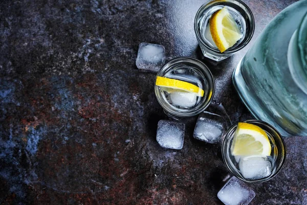 레몬과 얼음을 잔에 보드카 한잔입니다. 검은 돌 테이블에. Copyspace. — 스톡 사진