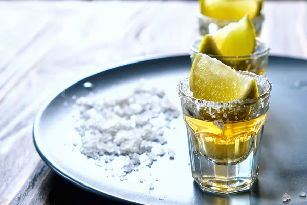 Tequila shot com limão e sal marinho na placa cinza — Fotografia de Stock