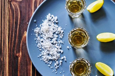 Limonlu tekila ve gri tabakta deniz tuzu.