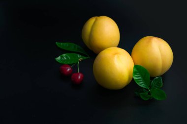 Siyah arka planda sarı şeftali ve kiraz
