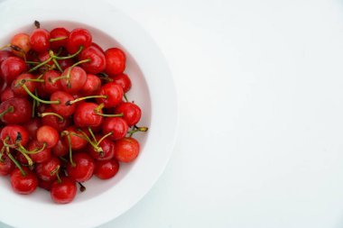 Beyaz porselen tabakta taze kirazlar..