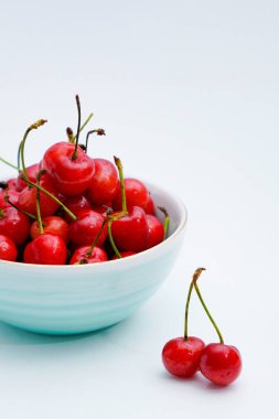 Açık mavi porselen tabakta kirazlar