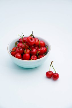 Açık mavi porselen tabakta kirazlar