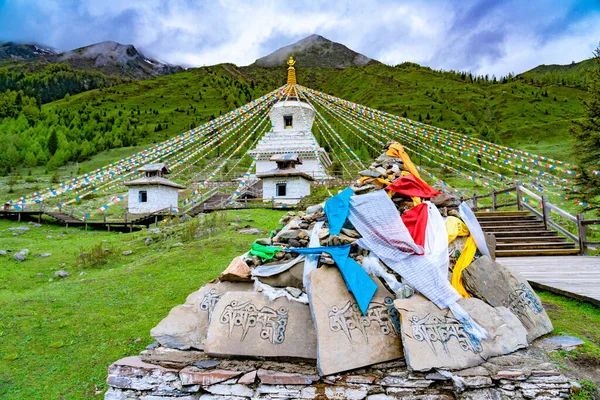 パゴダや祈りShuangqiaogou Siguniangshan 四川省 中国で チベットの白い塔の祈りの旗とマニ石 — ストック写真