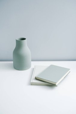 Masaya konulmuş minimalist defter ve vazo. Açık-beyaz premium mobilyalar 