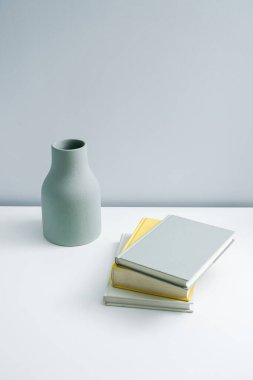 Masaya konulmuş minimalist defter ve vazo. Açık-beyaz premium mobilyalar 
