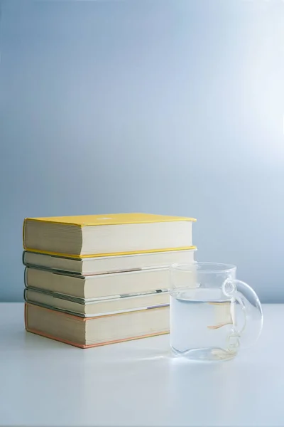 Een Stapel Boeken Een Glas Water Het Witte Bureau — Stockfoto