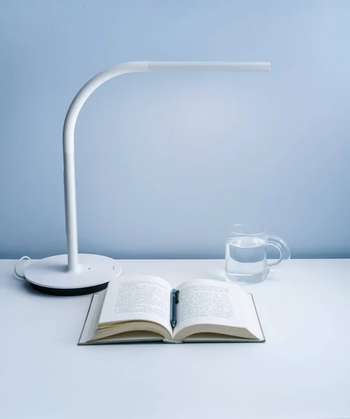 Staat Een Open Boek Een Witte Tafel Met Een Lamp — Stockfoto