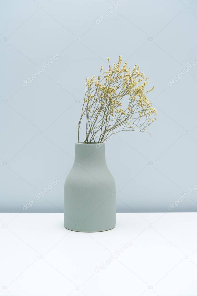 Put the vase with dried flowers on the white table