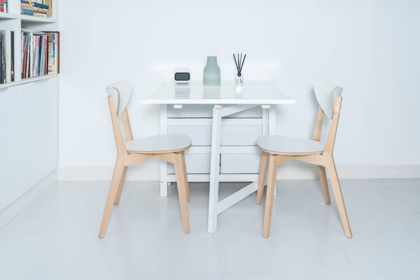 Working at home in a minimalist home. Dining tables and chairs and furnishings in a minimalist modern home. 