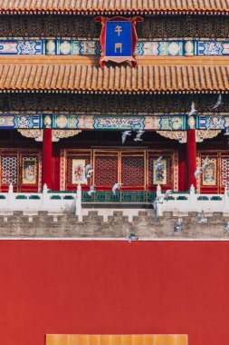 Pekin, Çin 'deki Yasak Şehir Meydanı' ndaki güvercinler. Pekin Yasak Şehri 'nde Kızıl Duvar' ın önünde uçan güvercinler. Resimdeki plaketin Çince çevirisi: Meridian Kapısı.