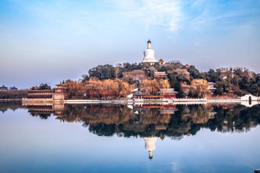 Pekin, Çin 'deki Beihai Park' taki beyaz kule. Beihai Parkı 'nda taş köprü ve göl suyu..
