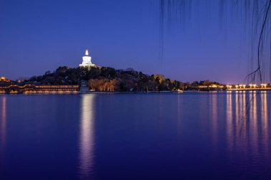 Pekin, Çin 'deki Pekin Parkı' nın gece manzarası. Beyaz Pagoda ve Beihai Park 'ta göl suyu, Pekin, Çin' de, Pekin Parkı, Pekin Gölü 'ndeki Qionghua adasının Gece Manzarası.