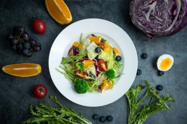 Bir tabak lezzetli ve sağlıklı sebze salatası. Gri beton zeminde bir tabak lezzetli ve sağlıklı sebze salatası..