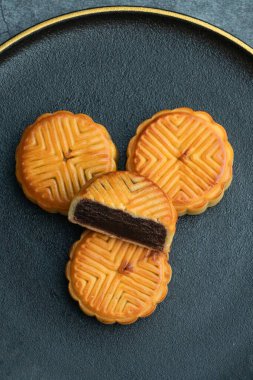 Sonbahar ortası festivali için ay çörekleri altın kaplamalı siyah bir tabağa konur.