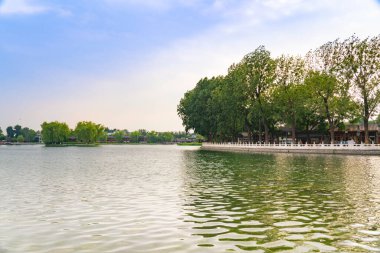 Çin, Pekin 'de Shichahai gün batımı. Güzel Shichahai Gölü Adası ve köpüklü göl suyu