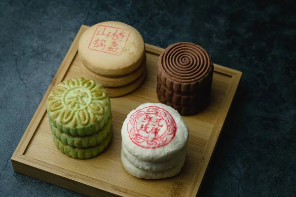 Delicious traditional Chinese pastry on a dark background. Chinese translation on pastry:Rose Cake with flowers, Hawthorn cake, Green tea crisp