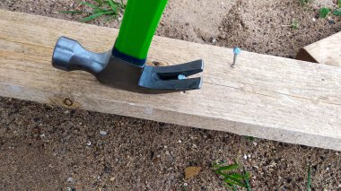 bir çekiç tahta bir çivi çeker