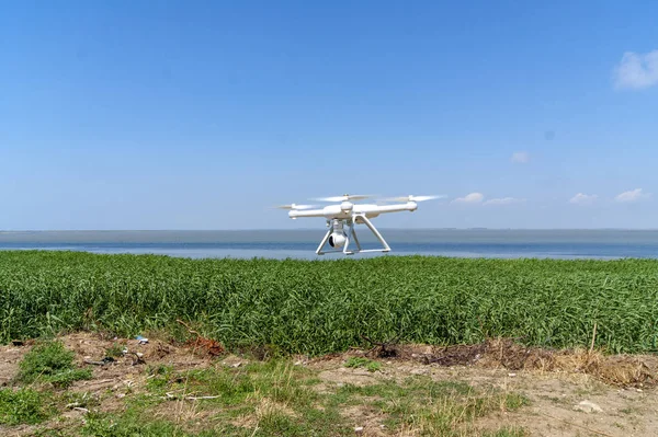 drone flies over land near the sea