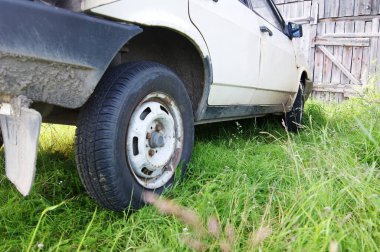 Eski bir Sovyet arabası çimlerin üzerinde duruyor.