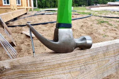 Bir çekiçle çiviyi tahtadan çıkar.